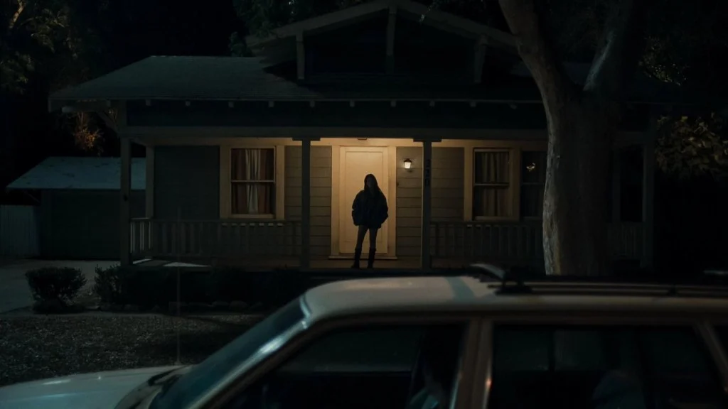 Nikki standing on porch in Obsession